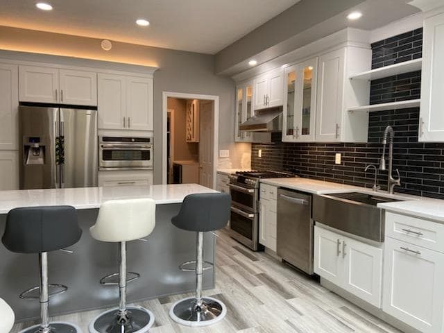 White kitchen with black backsplash and island seating