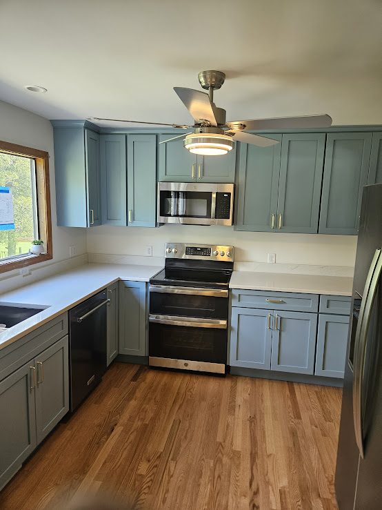 Sage blue shaker kitchen with white quartz countertops